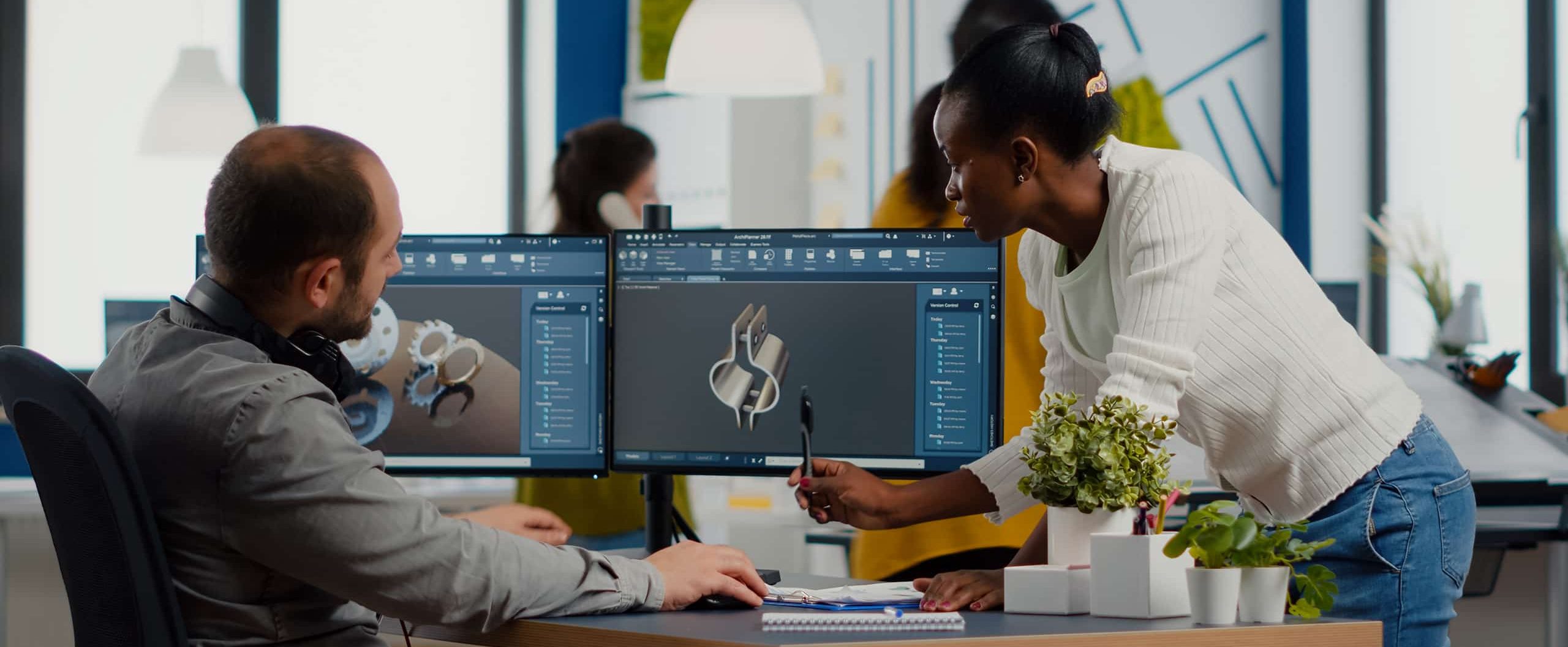 Employees viewing 3D renderings on a computer monitor